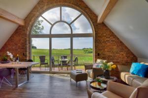 un soggiorno aperto con un muro di mattoni e una grande finestra di Ferienhaus Bootshaus in Nadelitz a Putbus Altre 9 foto