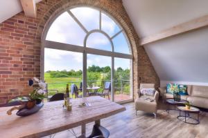 un soggiorno aperto con un muro di mattoni e una grande finestra di Ferienhaus Bootshaus in Nadelitz a Putbus