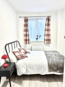 a bedroom with a bed and a window at 4B4B Entire House Sleeps 11 Driveway Parking near Coventry University and City Centre in Coventry