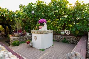 a statue of a dog sitting on a wall in a garden at House Ingrid in Rijeka