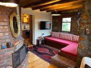 a living room with a red couch and a brick wall at MHome AGIOS ATHANASIOS in Palaios Agios Athanasios