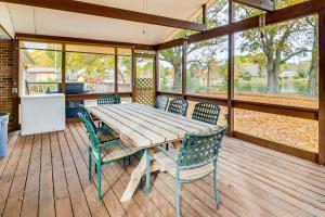 a wooden table and chairs on a wooden deck at Screened Patio, Deck and Grill Saint Inigoes Home! in Saint Inigoes Shores