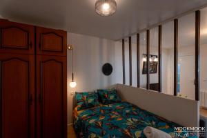 a living room with a couch and a mirror at COCO Studio in Maisons-Alfort