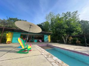 a chair and an umbrella next to a swimming pool at Casa campestre Namaste Entre La Mesa y Anapoima con piscina privada in La Mesa