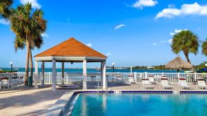 a swimming pool with a gazebo next to the ocean at Private Beach, 2 Pools & Hot Tub in St. Petersburg