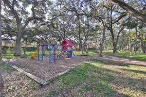 a park with two playground equipment in the grass at Private Beach, 2 Pools & Hot Tub in St. Petersburg