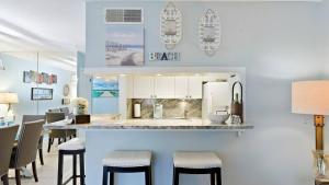 セント・ピーターズバーグにあるBeachside Condo Walk To Sand, Pool & Hot Tubのキッチン(スツール付きのバー付)