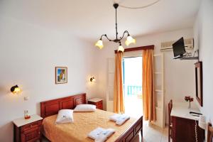 a bedroom with a large bed and a window at Karkisia Hotel in Aegiali