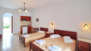 a bedroom with two beds and a kitchen at Karkisia Hotel in Aegiali +11 photos