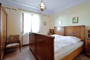 a bedroom with a bed and a chair and a window at Apartments Rosemary in Lucija