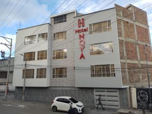 帕斯托Hotel NOVA的一辆白色汽车停在一栋建筑物前
