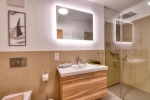 een badkamer met een wastafel, een douche en een spiegel bij Ferienwohnung Meereslauschen in der Villa Beatrice in Binz +13 foto's