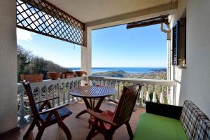balcón con mesa, sillas y vistas al océano en Apartments Rosemary en Lucija