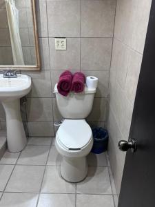 a bathroom with a toilet and a sink and two towels at Condominio 1 in San Felipe +1 photo