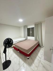 a bedroom with a bed and a fan in it at Recanto Martins in Ipojuca