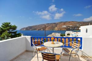a table and chairs on a balcony with a view of the water at Karkisia Hotel in Aegiali