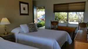 a bedroom with two beds and a window at Hilltop Tavern and Inn in Apple Valley