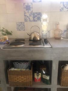 a tea kettle sitting on top of a stove in a kitchen at A Morriña in Santa Lucía