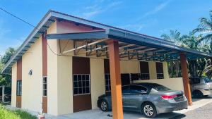 a house with a car parked in front of it at De Bunga Homestay in Parit Raja