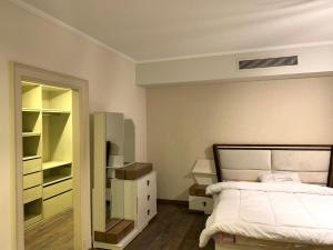 a bedroom with a bed and a dresser and a mirror at Apartment inside Westown Beverly Hills Compound, Sheikh Zayed رقم هاتف صفر صفر اتنين صفر واحد واحد صفر اتنين اربعه ثلاثه صفر 222 in Sheikh Zayed