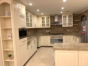 a large white kitchen with white cabinets and appliances at Apartment inside Westown Beverly Hills Compound, Sheikh Zayed رقم هاتف صفر صفر اتنين صفر واحد واحد صفر اتنين اربعه ثلاثه صفر 222 in Sheikh Zayed +19 photos
