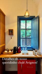 a kitchen with a counter with a window at Provence Cottage in Camanducaia