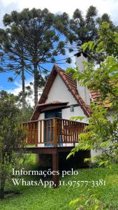 a house with a large deck with a porch at Provence Cottage in Camanducaia