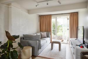 a living room with a couch and a tv at Coach Road Beach House in Indented Head