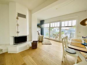 ein Wohnzimmer mit einem TV und einem Esstisch in der Unterkunft Ferienwohnung Binzer Seeblick Haus Jahreszeiten Binz in Binz