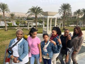 un gruppo di donne che si trovano di fronte a un edificio di Giza PYRAMIDS with camel ride a Ghaţāţī