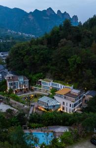张家界Zhangjiajie Rock language art hotel-Free pick up service的享有小镇的空中景色,以群山为背景