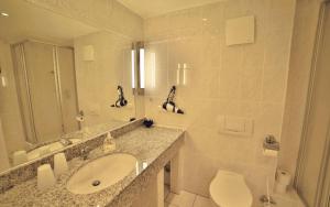 ein Badezimmer mit Waschbecken, Toilette und Spiegel in der Unterkunft Ferienwohnung Binzer Strandgut im Haus Jahreszeiten Binz in Binz