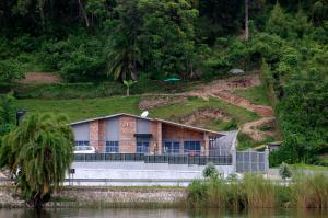 a house on the side of a hill next to a river at Spa Shallum in Kibuye