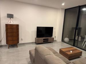 a living room with a couch and a flat screen tv at Residencial Sabina in Cabo San Lucas