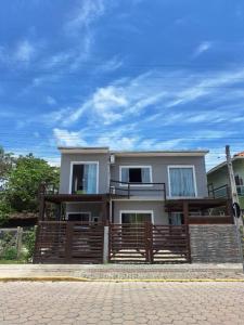 ボンビーニャスにあるResidencial Zimbros 2の木塀のある大白い家