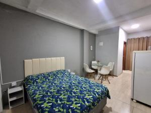 ボンビーニャスにあるResidencial Zimbros 2のベッドとテーブルと椅子のある寝室