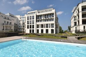 ein großes Schwimmbad vor einem Gebäude in der Unterkunft Ferienwohnung Luxus Apartment MeerFreude Sellin in Ostseebad Sellin