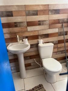a bathroom with a toilet and a sink at Casa branca in Marataizes