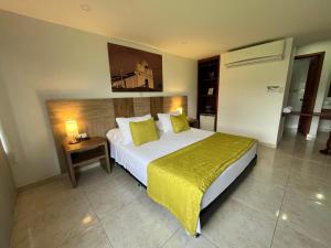 a bedroom with a large bed with a yellow blanket at Hotel Los Viñedos in Lemos +47 photos