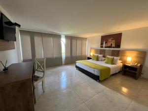 a bedroom with a bed and a table and a desk at Hotel Los Viñedos in Lemos