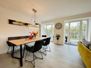 a dining room and living room with a table and chairs at Ferienwohnung Ruhepol im Haus Zudar Prora in Binz