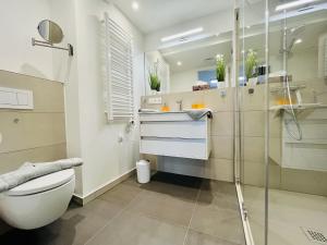 a bathroom with a toilet and a glass shower at Ferienwohnung Ruhepol im Haus Zudar Prora in Binz +23 photos
