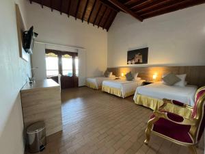 a hotel room with two beds and a couch at Hotel Los Viñedos in Lemos
