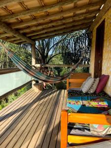 a hammock on the deck of a house at Sunset Lagoon Praia do Rosa in Praia do Rosa