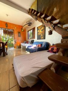 a bedroom with a bed and a couch in a room at Sunset Lagoon Praia do Rosa in Praia do Rosa