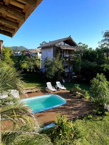 a backyard with a swimming pool and a house at Sunset Lagoon Praia do Rosa in Praia do Rosa