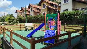 a playground with a slide in front of a fence at Linda casa de veraneio em Gravatá in Gravatá