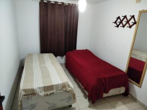 a small room with two beds and a mirror at Linda casa de veraneio em Gravatá in Gravatá