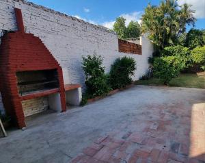 a brick wall with a brick fireplace next to a patio at Mi Rinconcito in Asunción