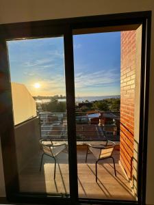 two chairs on a balcony with a view of the city at DPTO 405 Edif Loftier in Posadas +7 photos